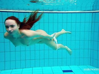 Russian redhead teen with small tits dives deep in the pool
