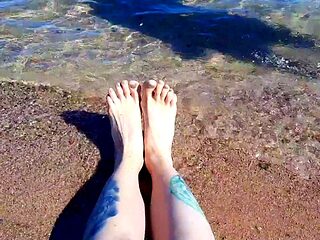 Dominatrix Nika enjoys the salty sea on her feet.           
