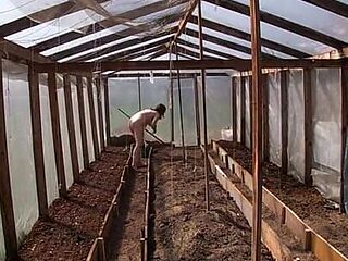 Nude house wife working in the greenhouse