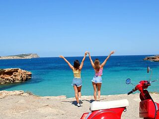 Two hot girls have fun on the beach with their bikinis on